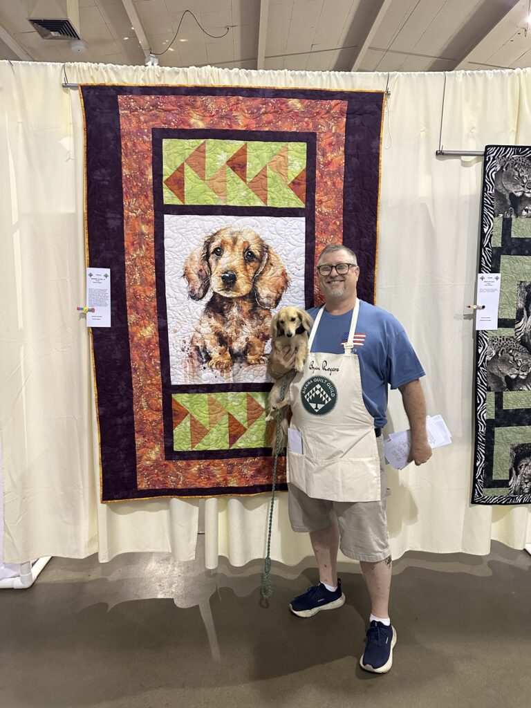 Matilda and her quilt — Portrait of Bryan’s English Cream Dachshund and trained Psychiatric Support Service Animal, shown at the Sierra Quilt Guild show.